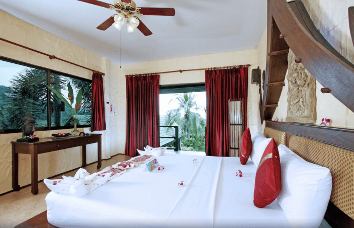 Boomerang Resort Phuket - camera 7 con cuscini rossi e tende e vista resort